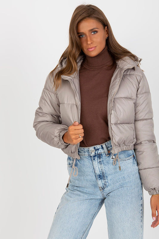 Luxury Women's Down Quilted Jacket with Detachable Hood and Zippered Pockets, elegantly styled with a turtleneck sweater and high-waisted denim, showcasing a chic, sophisticated look.