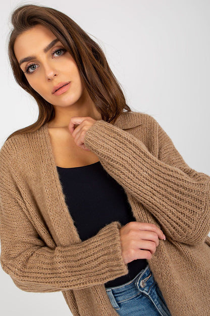 Close-up of the Och Bella Unbuttoned Cardigan with Long Wide Sleeves and Contrasting Lettering, showcasing its sumptuous brown fabric and intricate knit design.