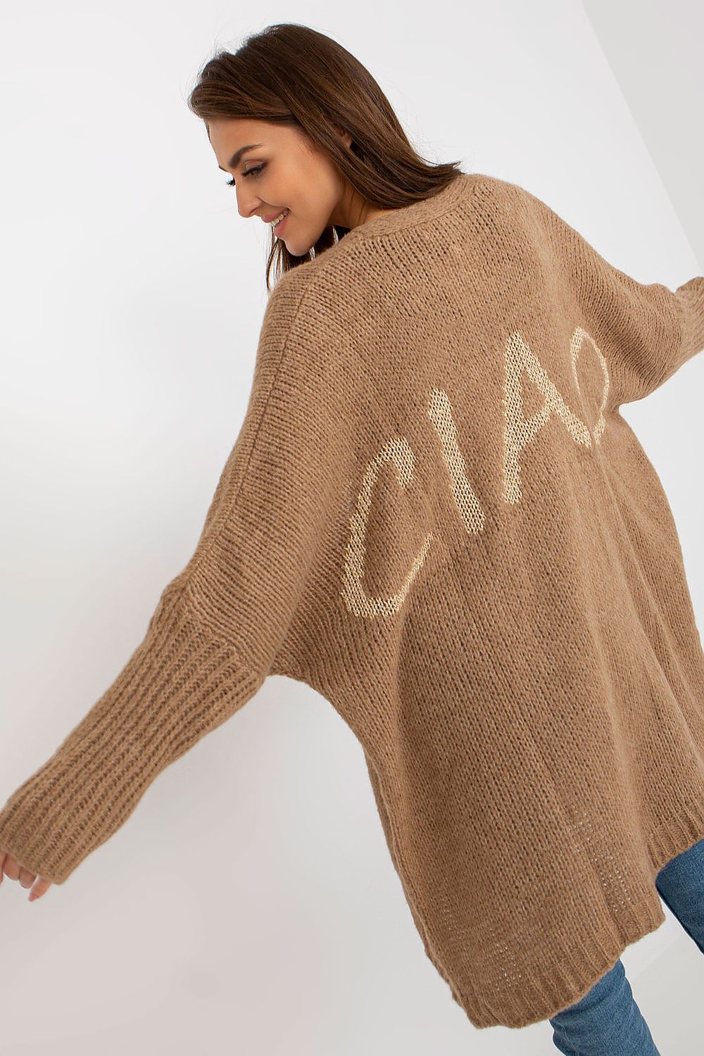 Chic portrayal of a model in the Och Bella Unbuttoned Cardigan with Long Wide Sleeves and Contrasting Lettering, featuring a luxurious brown tone and stylish ‘CIAO’ lettering.