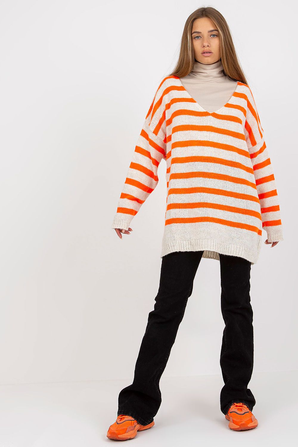 Och Bella Women's Colourful Striped Sweater with Long Sleeves and V-Neck Design, presented in a fashion-forward outfit with relaxed black trousers and bright orange sneakers, highlighting a contemporary and luxurious appeal.
