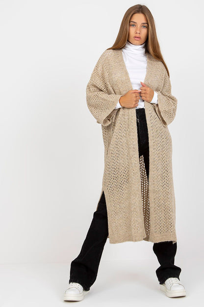 Stylish and cozy Elegant Openwork Long Sleeve Cardigan by Och Bella, featuring an openwork pattern, worn with a turtleneck top, paired with black trousers and sneakers, creating a luxurious casual look.