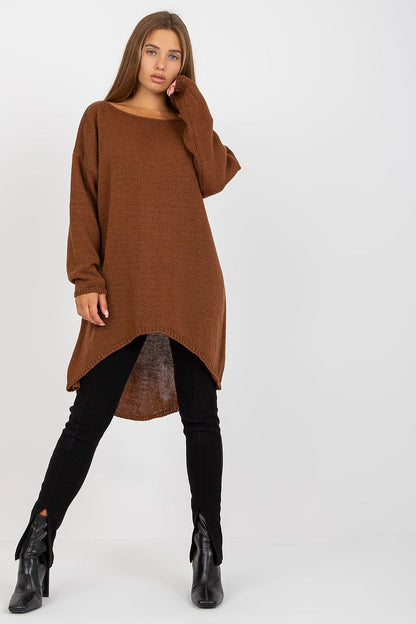 Luxury Women’s Asymmetrical Cut Sweater by Och Bella, model posing in a brown long-sleeved sweater with an asymmetrical hem, elegantly styled with black pants and heeled boots.