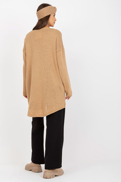 Luxury Women’s Asymmetrical Cut Sweater by Och Bella, model posing from the back in a beige asymmetrical cut sweater paired with black wide-leg trousers, showcasing a contemporary and luxe design.