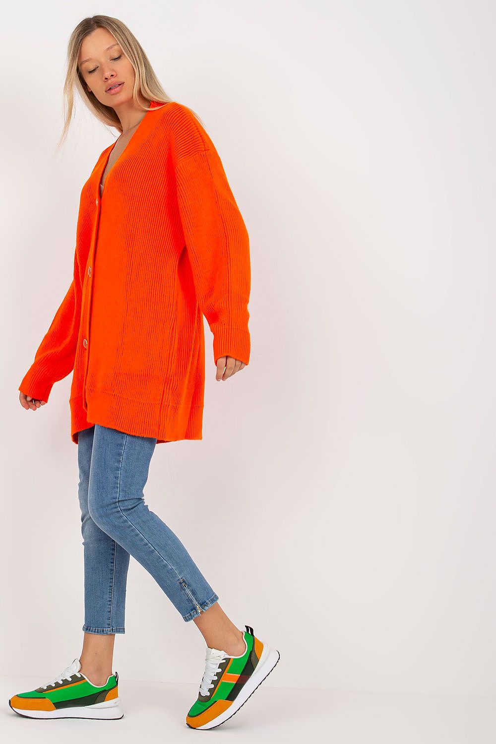 Elegant Extended Cut Cardigan by Rue Paris in bright orange, presented with a button closure and long sleeves, elegantly paired with skinny jeans for a trendy look.