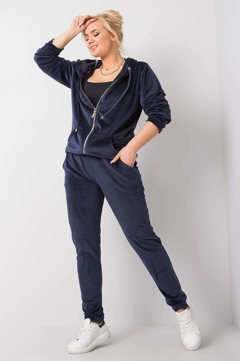 Luxurious Plus Size Velour Set: Zip-Up Hoodie and Tie-Waist Pants for Ultimate Comfort - Model showcasing navy velour tracksuit with long sleeves, zippered hoodie, and tie-waist pants, styled with white sneakers.
