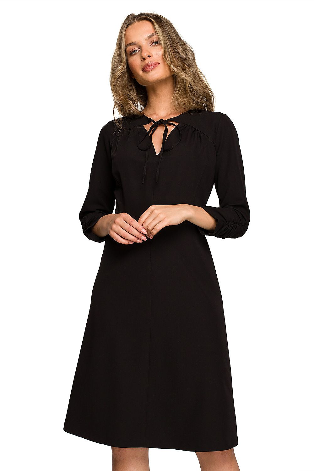 Classic black daydress with a stylish tie-neck, elegantly styled on a model, perfect for formal and casual occasions.