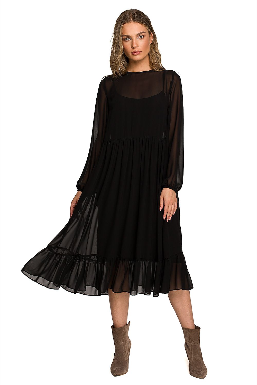 Sophisticated woman wearing a black chiffon cocktail dress with ruffled hem and wide sleeves, radiating elegance in a luxurious evening setting.