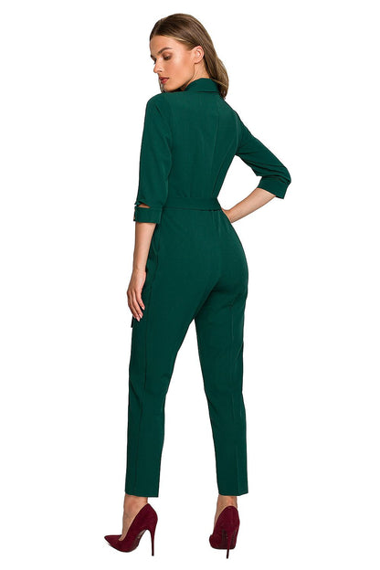 Back view of a luxurious green jumpsuit by Stylove, showcasing the elegant shawl collar and a defining waist tie for a sophisticated silhouette.