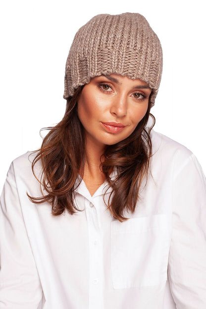 Stylish model wearing a luxurious beige thick-weave beanie cap with ribbed brim, radiating warmth and fashion-forward charm.