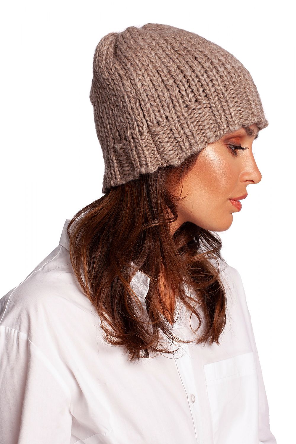 Elegant woman showcasing a luxury warm thick-weave beanie cap with ribbed brim, crafted from a blend of acrylic, nylon, and wool. Perfect for winter styling.