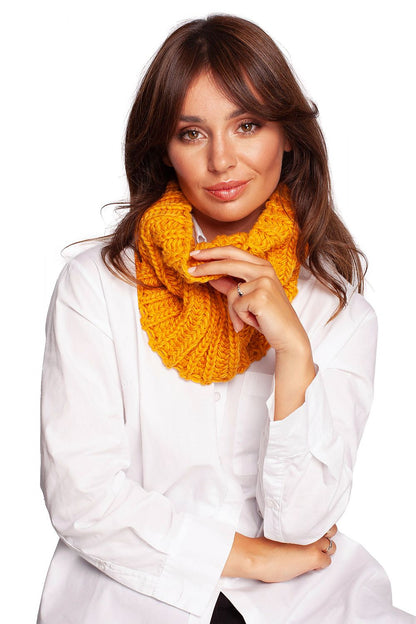 Stylish woman wearing a luxurious golden yellow acrylic infinity scarf, showcasing cosy warmth perfect for autumn and winter fashion.