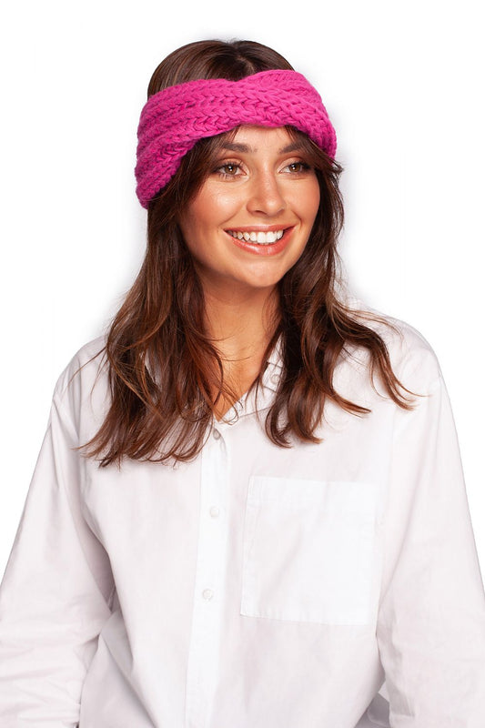 Luxurious pink knitted headband by BE Knit, showcased on a smiling model wearing a white blouse, perfect for stylish winter warmth.