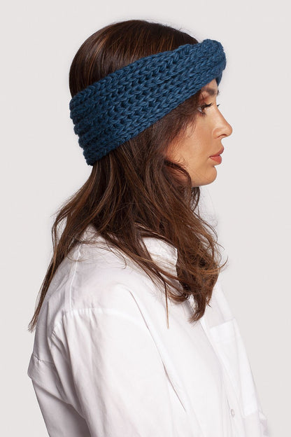 Side view of a sophisticated blue headband by BE Knit, elegantly presented on a model in a white shirt, ideal for luxury winter styling.