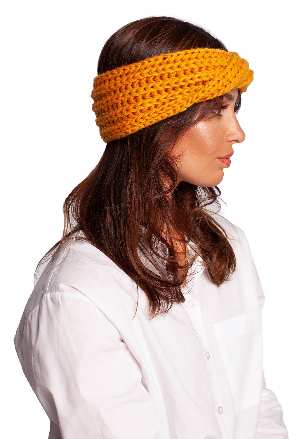 Side profile of a chic woman showcasing a luxurious warm yellow headband by BE Knit, offering both comfort and style for cold weather.