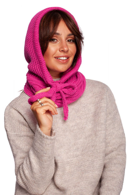 A stylish woman showcasing the luxurious infinity scarf by BE Knit in a vibrant pink colour, elegantly draped around her neck while wearing a soft beige sweater, capturing the essence of warm autumn fashion.