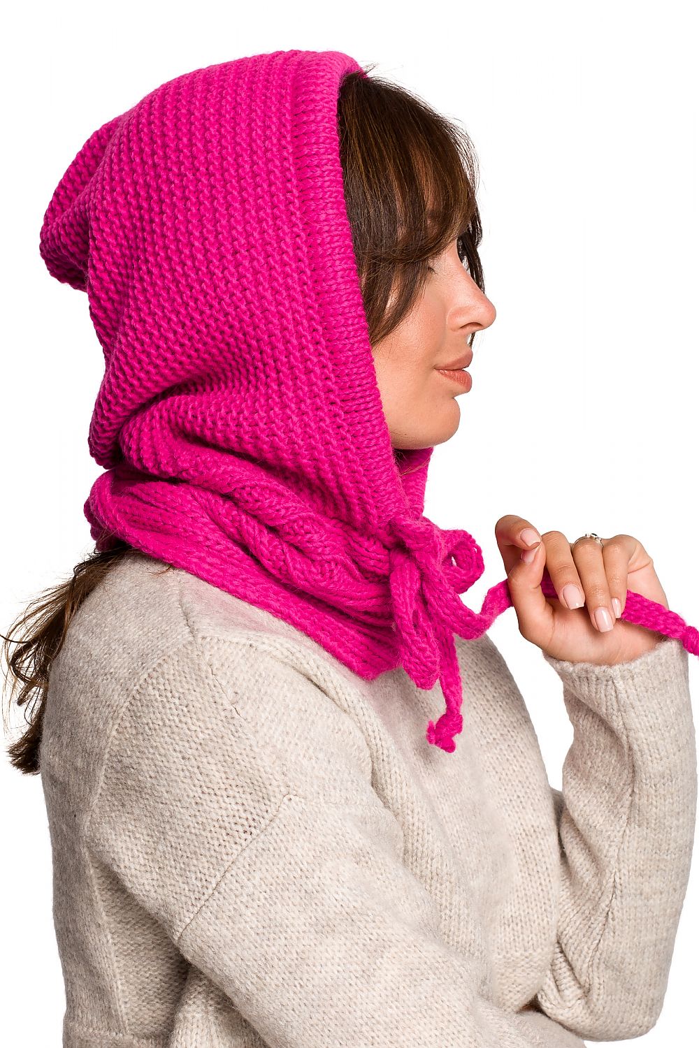 A close-up profile of a fashionable woman wearing a luxurious pink infinity scarf by BE Knit, highlighting the intricate weave and cozy design, complemented by her chic beige sweater.