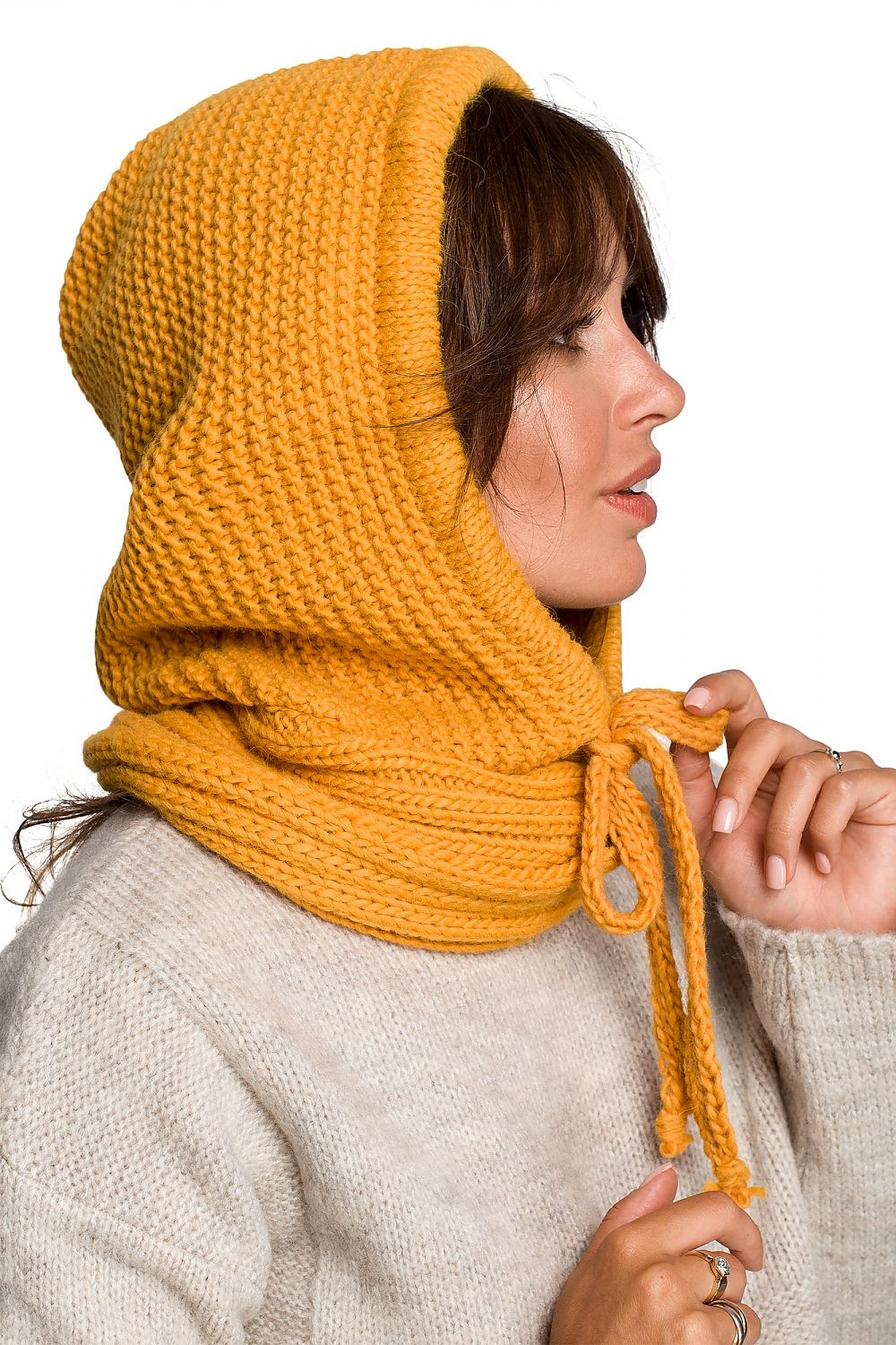 Chic side view of a model wearing a vibrant yellow infinity scarf, embodying warmth and autumn elegance in a modern knitted style.