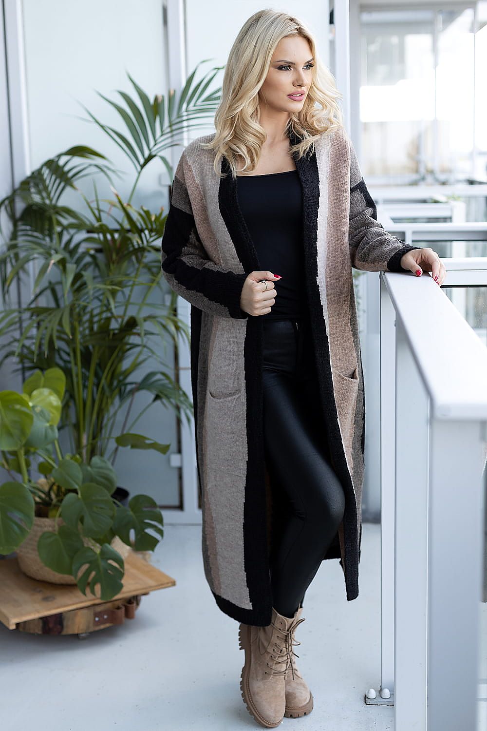 Luxurious long sleeve cardigan fashioned from soft fluffy fabric by PeeKaBoo, showcased in an elegant indoor setting, featuring neutral tones and pockets, paired with chic black leggings and stylish beige boots.