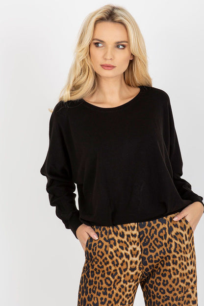 Elegant women's black sweater with a boat neckline, featuring long sleeves and styled with leopard print trousers.
