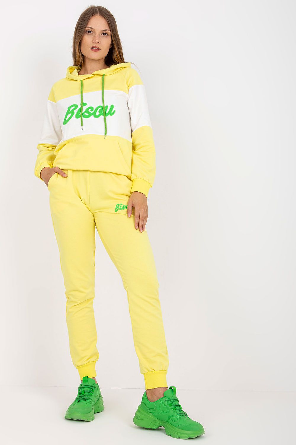 Luxury cotton blend hoodie and sweatpants set in vibrant yellow, featuring a stylish decorative patch and green accents, ideal for a chic casual look. Model showcasing the comfortable fit and contemporary design, perfect for both lounging and outdoor activities.