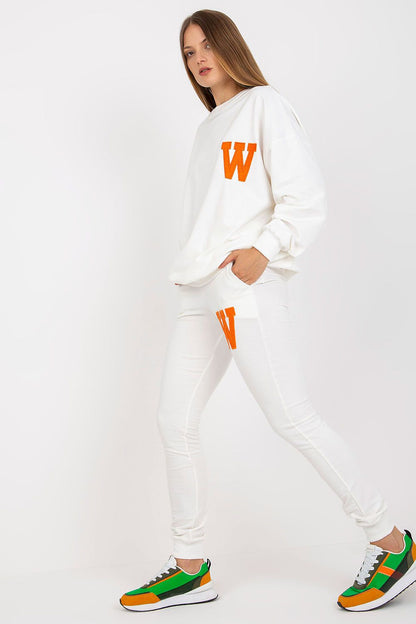 Sophisticated white sweatsuit ensemble with bold orange 'W' patches on the sweatshirt and pants, perfectly styled with trendy casual trainers for a luxe athleisure aesthetic.