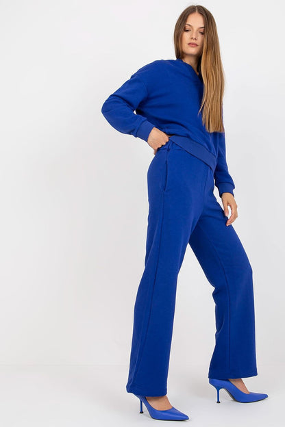 Elegant blue women's hoodie and pants set in cotton, showcasing long sleeves and side pockets, model posing in chic high heels.