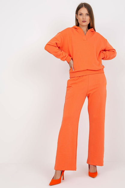 Vibrant orange women's cotton sweatshirt and pants set with a hood and slip pockets, model exuding confidence in striking high heels.