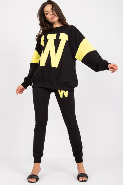 Sophisticated women's tracksuit set in black with bright yellow accents, designed with a loose sweatshirt and tailored pants, ideal for a stylish streetwear appearance.