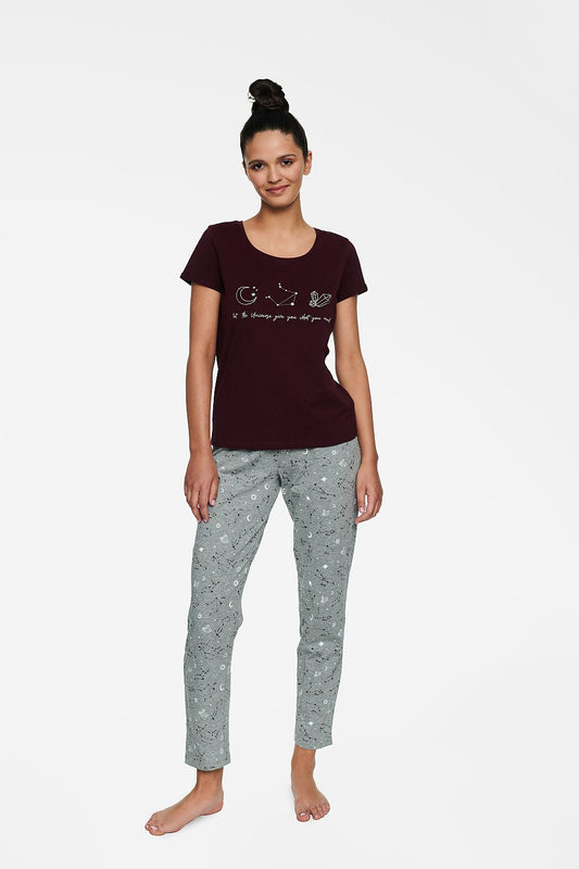 Stylish model showcasing Henderson's Women's Luxury Cotton Pyjamas set featuring a short sleeve maroon blouse adorned with intricate design and light grey long elastic waist pants printed with celestial motifs, exemplifying luxury loungewear.