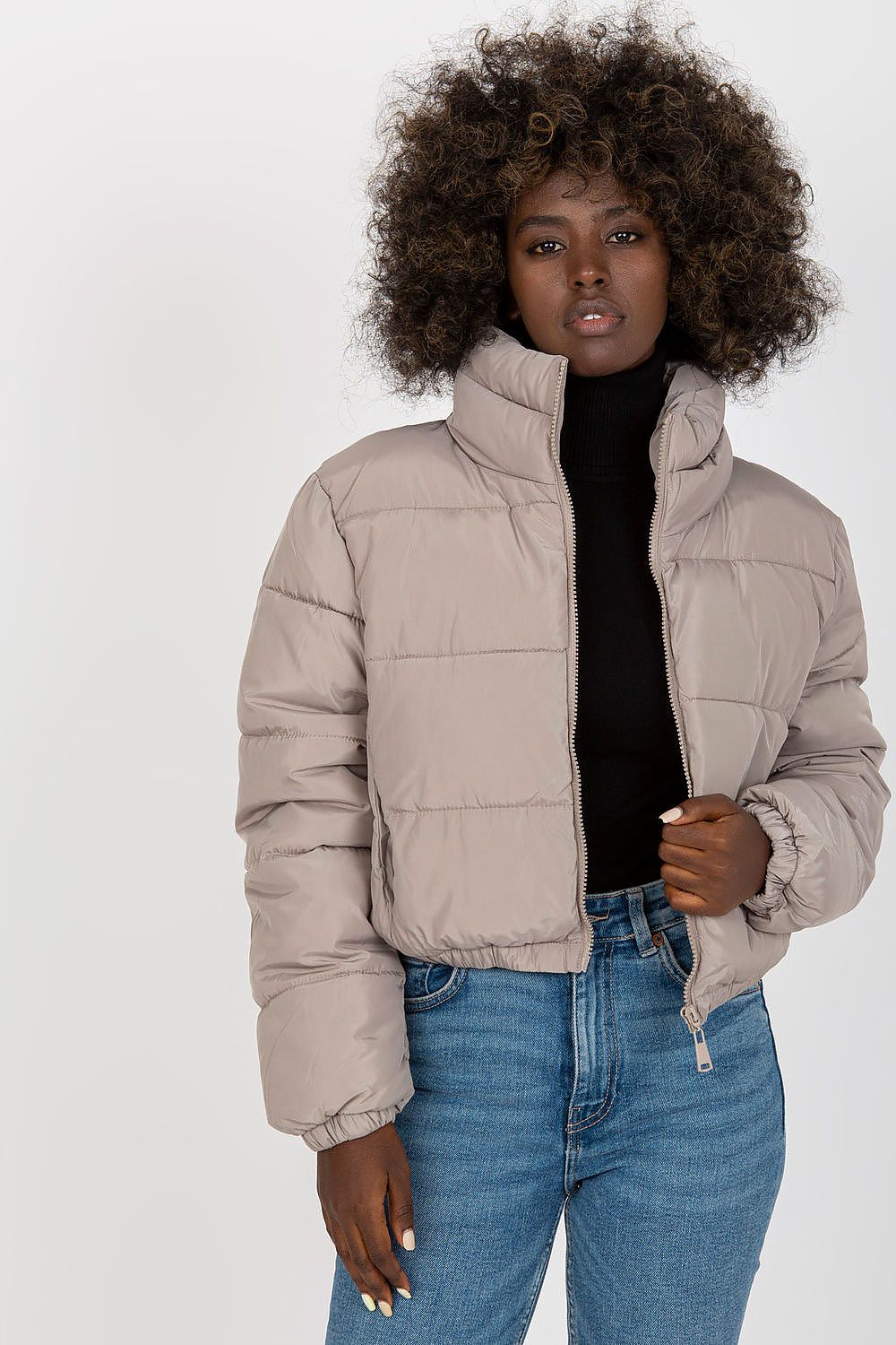 Luxurious 100% polyester quilted jacket in soft beige, featuring a stylish zip closure and non-removable hood, modelled elegantly against a neutral background.