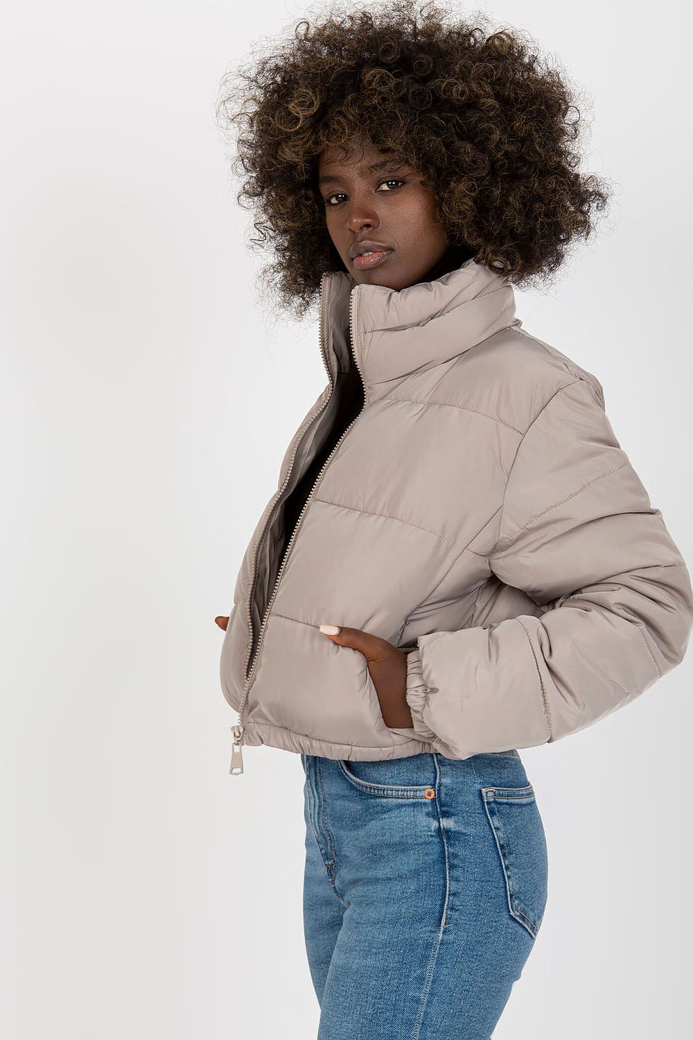 Chic short quilted jacket in beige with a contemporary design, showcasing a model in a stylish pose, perfect for luxury winter fashion.