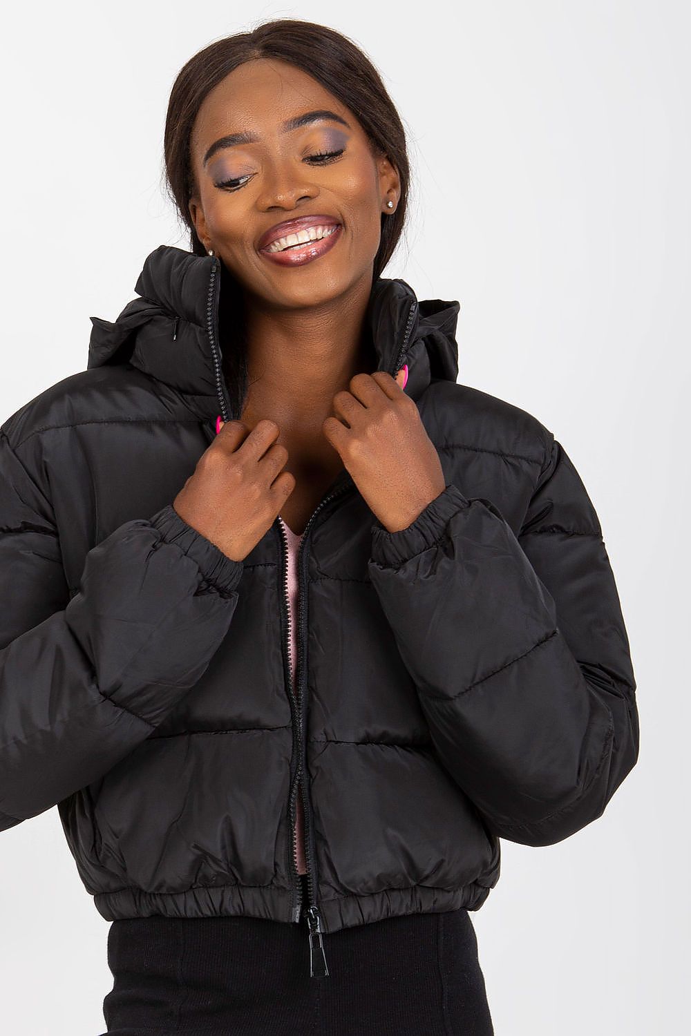 Elegant black quilted jacket with a hood, showcased by a smiling model, perfect for a fashionable and functional winter wardrobe.