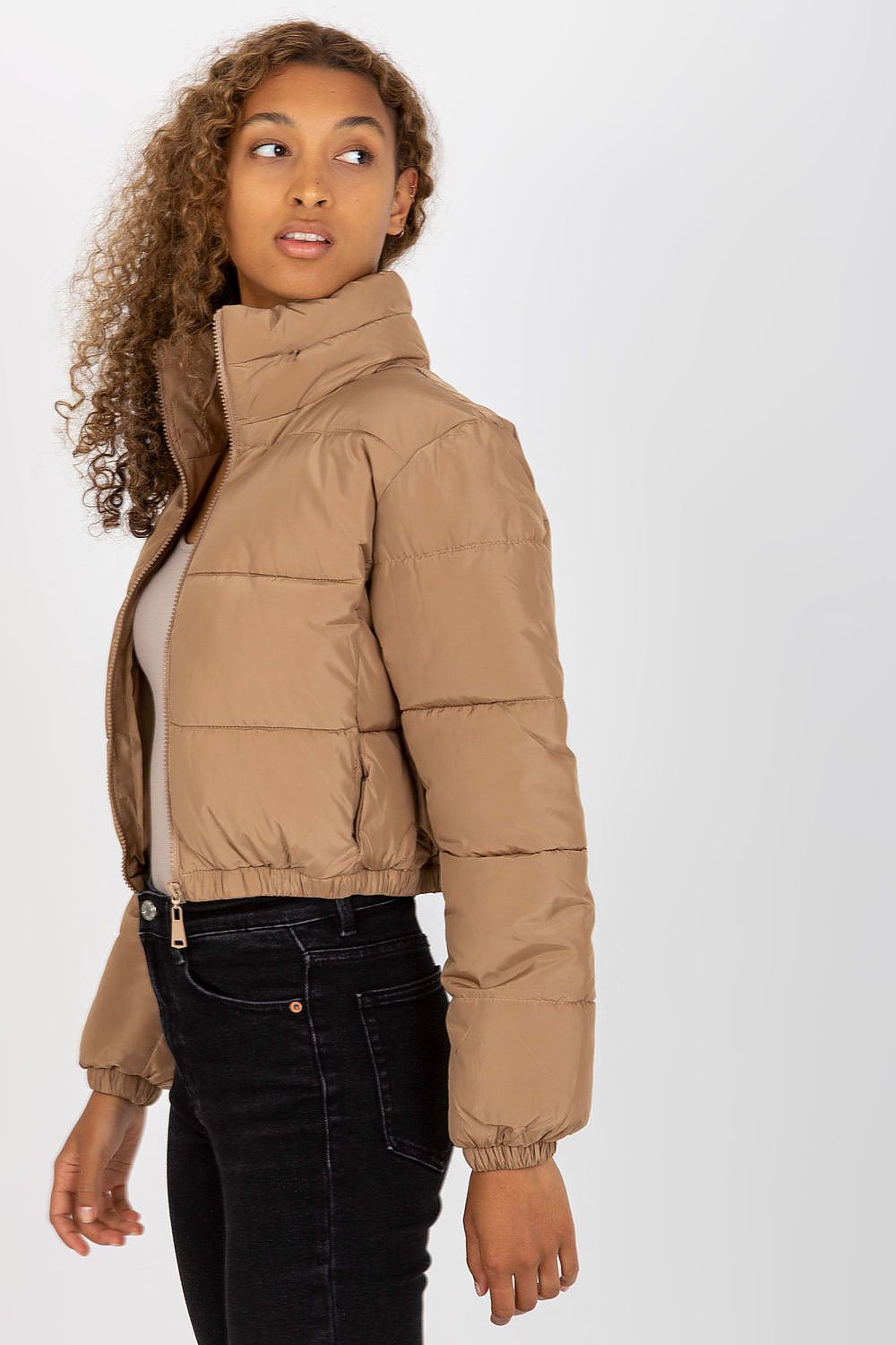 Side profile of a sophisticated model in a luxurious brown quilted jacket, showcasing the elegant fit and contemporary design, paired with chic black denim.