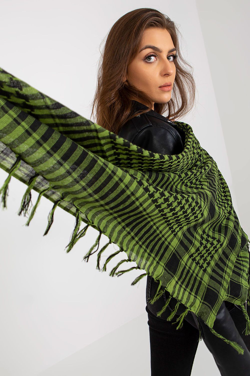 Sophisticated green checkered neckerchief scarf elegantly wrapped around a model's shoulders, highlighting its stylish pattern and luxury fabric in a serene atmosphere.