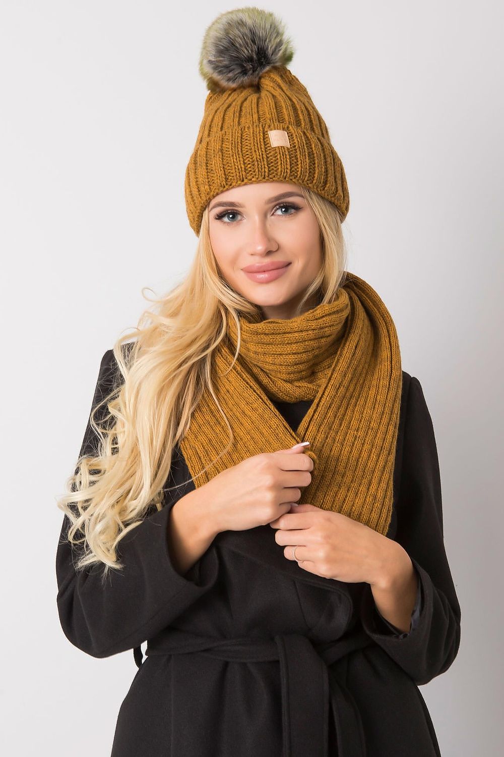 Glamorous model wearing a luxurious mustard winter hat and scarf set, featuring an elegant ribbed design, perfect for adding sophistication to winter attire.