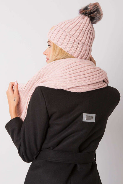 Fashionable view of a lady in a pink knit hat and scarf, presenting contemporary luxury winter attire.