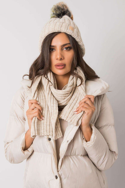 Stylish woman wearing a cream knitted beanie and scarf, showcasing elegant winter fashion paired with a puffer coat.
