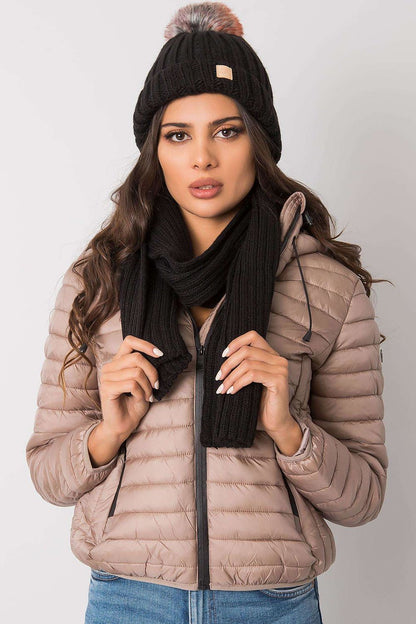 Luxurious winter hat and scarf set in black, showcasing a stylish woman wearing them with a chic puffer jacket and gloves, perfect for winter fashion.