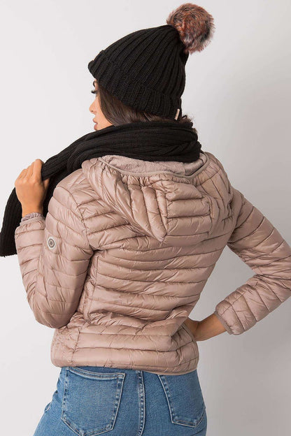 Back view of a stylish woman in a black hat and scarf set, adorned with a luxurious puffer jacket, emphasising warmth and fashion in winter wear.