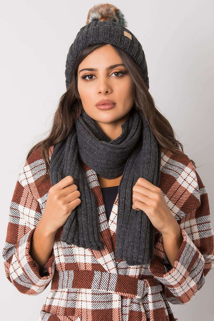 Sophisticated winter hat and scarf set in charcoal grey, worn by a fashionable woman in a stylish brown plaid coat, enhancing her chic winter look.