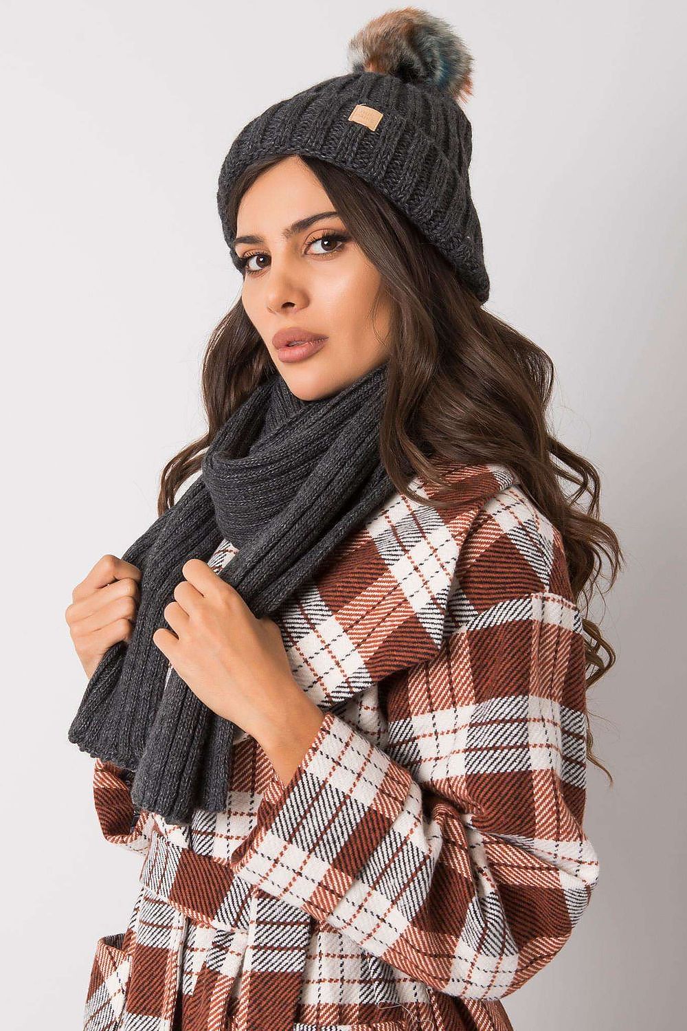 Trendy grey winter hat and scarf set, elegantly showcased by a stylish woman in a warm plaid coat, perfect for completing a luxurious winter ensemble.