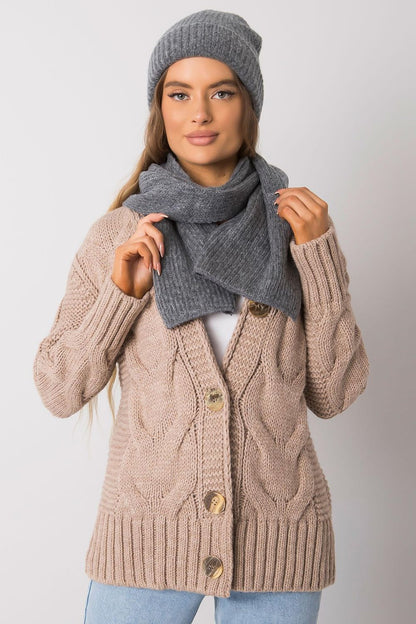 Sophisticated woman wearing a luxurious grey acrylic and wool hat and scarf set, styled with a chic cable knit cardigan, exuding elegance for the winter season.