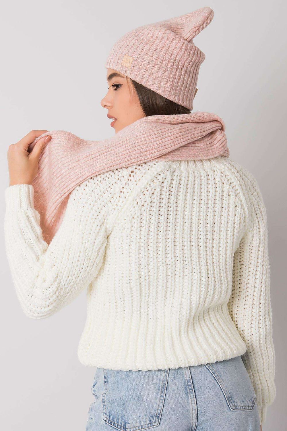 Luxurious acrylic winter hat and scarf set in soft pink, styled with cozy knit sweater for a chic winter look.