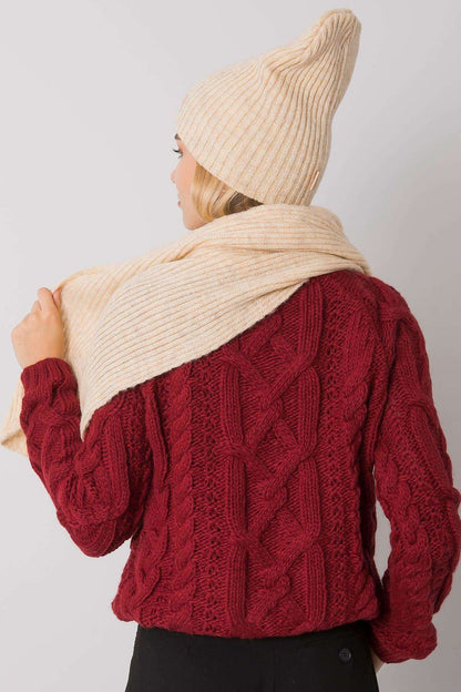 Rear view of a model showcasing the refined cream acrylic winter scarf draped elegantly under a matching beanie.