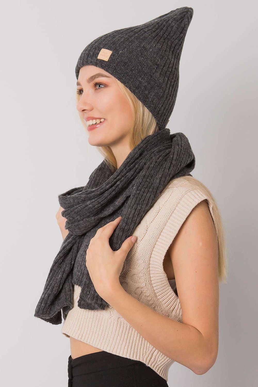 Luxurious grey acrylic winter hat and scarf set by Rue Paris, elegantly styled on a model with a neutral background, showcasing modern winter fashion.