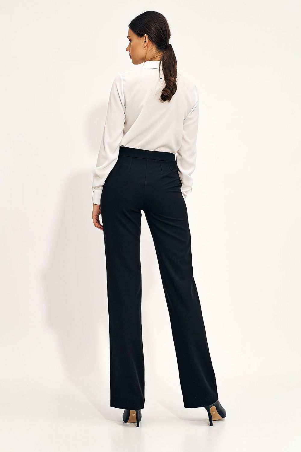 Back view of elegant high-rise wide-leg trousers for women by Nife with button details, styled with a sophisticated white blouse, showcasing luxe fashion.