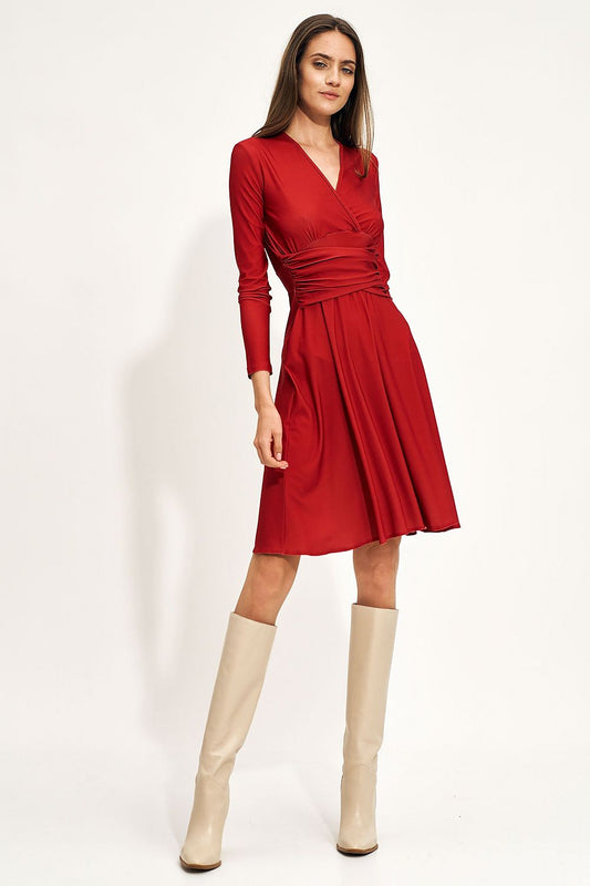 Fashionable red midi dress with long sleeves and flattering creased waist, worn with stylish beige high-heeled boots.