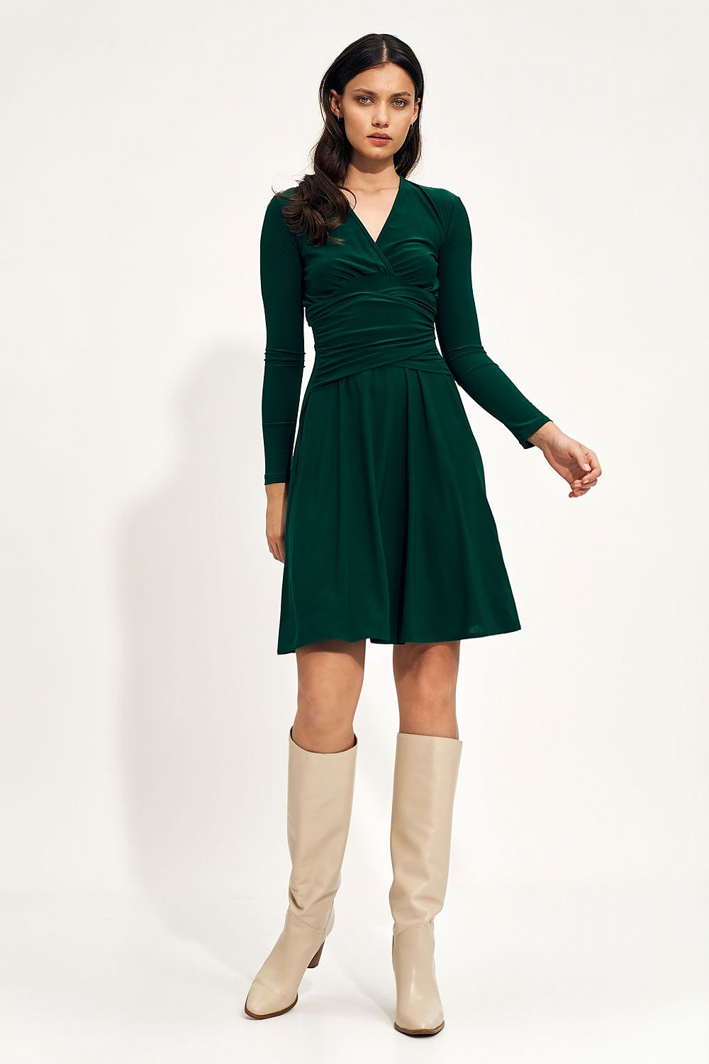 Sophisticated green midi dress with gathered waist and elegant envelope neckline, paired with fashionable beige knee-high boots, perfect for autumn elegance.