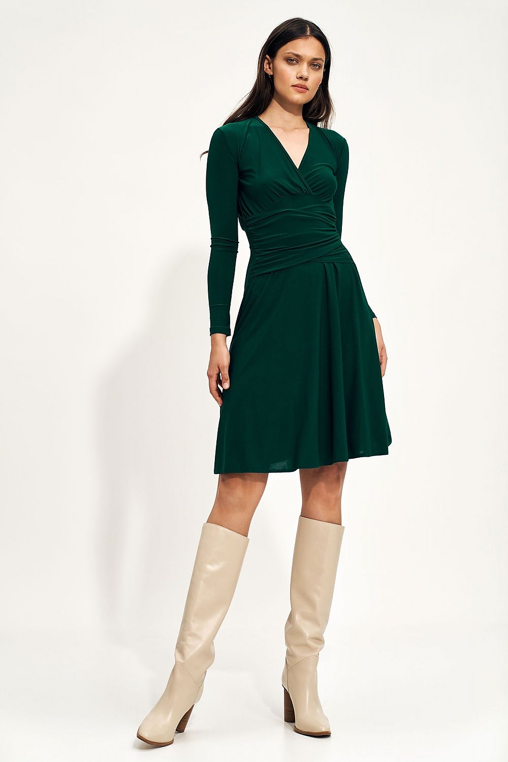 Chic green midi dress featuring a stylish envelope neckline and delicate waist detailing, complemented by elegant beige knee-high boots for a fashionable autumn look.