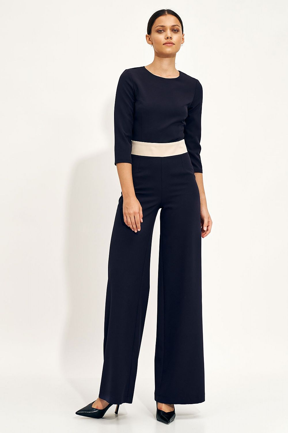 Elegant navy blue one-piece classic jumpsuit with fitted top and wide legs, worn by a model, showcasing a sophisticated silhouette.